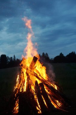              Letonya 'da yaz arifesinde büyük bir şenlik ateşi yanıyor. Kırsal alanda akşam vakti parlak şenlik ateşi yanıyor.                  