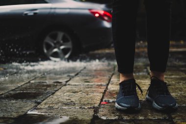 İlkbaharda yağmurlu bir sonbahar öğleden sonra. Yolun kenarında duran bir kız. Bulanık su birikintisi, gri metalik Alman arabasıyla su birikintisine doğru uçarken etrafa sıçrıyor..