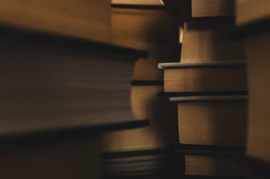 Kitapların Labirenti 'nin içinde. Sıcak sarı ve kahverengi sayfalı kitap yığınlarının arasından bir bakış.