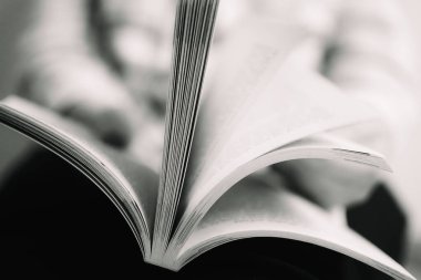 Çok bulanık arkaplanı olan açık bir kitabın iç karartıcı siyah beyaz renkleri