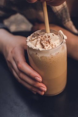 Bir kız ziyaretçi sütlü sütünü içiyor ve çikolatayı pipetle eritiyor.