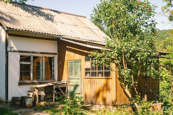 Summer cottage against cozy green background of a garden and trees