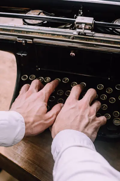 A writer using a vintage typewriter, writing his next novel