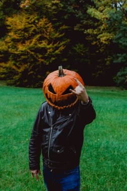 Siyah deri ceket giyen ve Jack o fener kostümü giyen bir adam kameraya boynuz doğrultuyor. Cadılar Bayramı ruhu kavramı