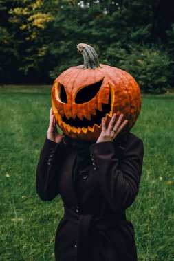 Cadılar bayramında balkabağı kafalı bir kadın ormanda. Bir kadın için Cadılar Bayramı kostümü fikri