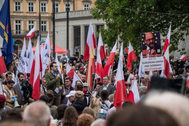 Varşova, Polonya, 19 Temmuz 2025. Göçmenlik politikasına karşı bir gösteri sırasında konuşma yapan bir konuşmacı. Bir pankart şöyle diyor: Avrupa Birliği ve Almanya diktatörlüğüne hayır
