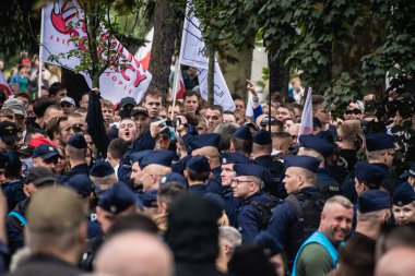Varşova, Polonya, 19 Temmuz 2025. Kızgın milliyetçi protestocular, şehir meydanında düzenlenen hararetli bir göç karşıtı gösteri sırasında bariz bir öfkeyle sloganlar attılar..