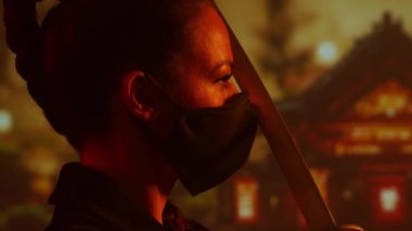 Maskeli ve katanalı genç ve güzel bir ninja kız. Geleneksel bir Japon tapınağının arka planındaki samuray kadın..