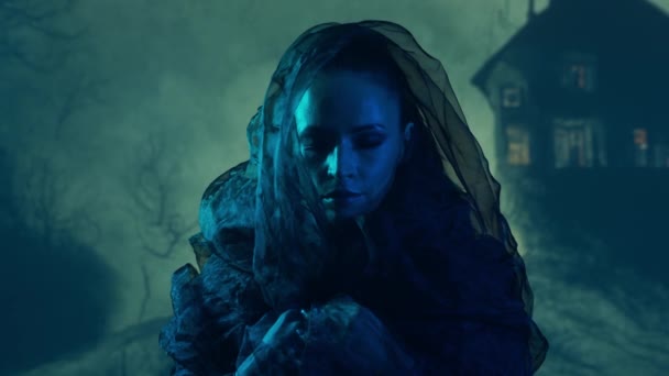 美丽的女巫使巫术笼罩在烟雾弥漫的背景中 山上可怕的房子 万圣节图像 — 图库视频影像