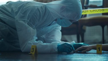 Detective Collecting Evidence in a Crime Scene. Forensic Specialists Making Expertise at Home of a Dead Person. The Concept of Homicide Investigation by Professional Police Officer.