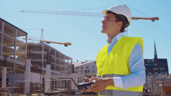 Drohnenbetreiber Mit Fernbedienung Professionelle Bauarbeiter Helm Und Weste Stehen Vor — Stockfoto
