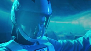 Yörünge istasyonunda uzay giysisi giymiş bir kadın astronot. Genç bir dişi kozmonot bir uzay gemisine pilotluk yapıyor. Galaktik seyahat ve bilim konsepti.
