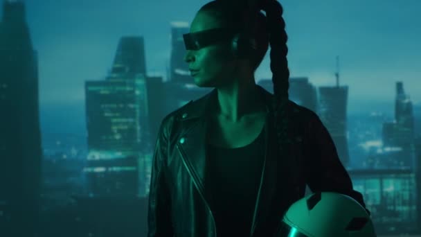 眼鏡とヘッドフォンのサイバーパンクの女の子の肖像画 都市の高層ビルの背景に美しい若い女性 未来的概念 — ストック動画