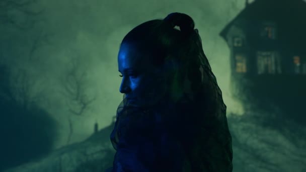 美丽的女巫使巫术笼罩在烟雾弥漫的背景中 山上可怕的房子 万圣节图像 — 图库视频影像