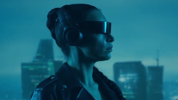 Portré Cyberpunk Lányról Szemüvegben Fejhallgatóban Gyönyörű Fiatal Városi Felhőkarcolók Hátterében — Stock videók