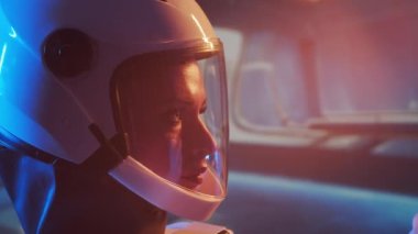 Yörünge istasyonunda uzay giysisi giymiş bir kadın astronot. Genç bir dişi kozmonot bir uzay gemisine pilotluk yapıyor. Galaktik seyahat ve bilim konsepti.