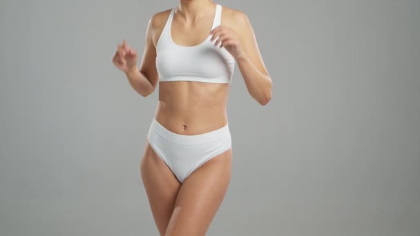身穿白色泳衣的女人摆出灰色背景的姿势 体育和健身的概念 — 图库视频影像