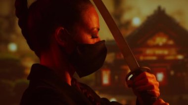 Maskeli ve katanalı genç ve güzel bir ninja kız. Geleneksel bir Japon tapınağının arka planındaki samuray kadın..