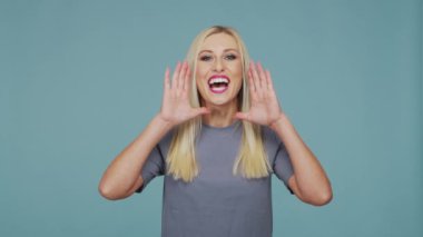 Stüdyodaki güzel sarışın kız. Mavi arka planda sevimli ve duygusal bir kızın portresi.