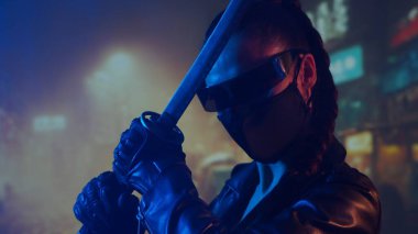 Maskeli ve katanalı siber-punk ninja kız. Şehir merkezindeki Asya şehrinin arka planında güzel bir kadın samuray..