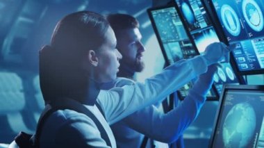 Yörünge istasyonunda uzay giysileri içinde bir astronot ekibi. Uzay gemisine pilotluk eden bir kozmonot mürettebatı. Uzayda kadın ve erkek. Galaktik seyahat ve bilim konsepti.