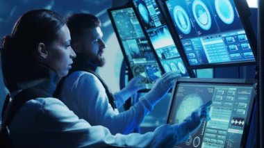 Yörünge istasyonunda uzay giysileri içinde bir astronot ekibi. Uzay gemisine pilotluk eden bir kozmonot mürettebatı. Uzayda kadın ve erkek. Galaktik seyahat ve bilim konsepti.