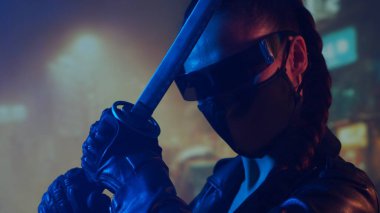 Maskeli ve katanalı siber-punk ninja kız. Şehir merkezindeki Asya şehrinin arka planında güzel bir kadın samuray..