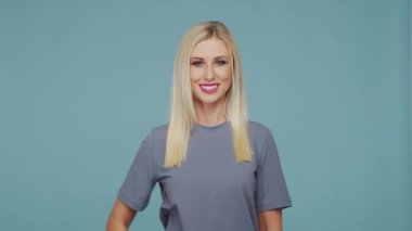 Stüdyodaki güzel sarışın kız. Mavi arka planda sevimli ve duygusal bir kızın portresi.