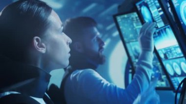 Yörünge istasyonunda uzay giysileri içinde bir astronot ekibi. Uzay gemisine pilotluk eden bir kozmonot mürettebatı. Uzayda kadın ve erkek. Galaktik seyahat ve bilim konsepti.