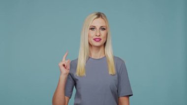 Stüdyodaki güzel sarışın kız. Mavi arka planda sevimli ve duygusal bir kızın portresi.