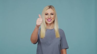 Stüdyodaki güzel sarışın kız. Mavi arka planda sevimli ve duygusal bir kızın portresi.