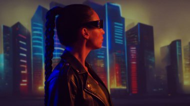 Siber punk kızı portresi. Şehir tırpanlarının arka planında güzel bir genç kadın. Gelecekçi kavram.