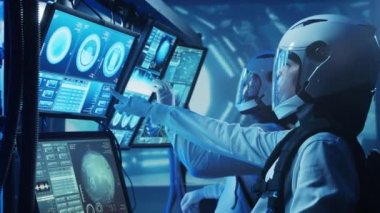 Yörünge istasyonunda uzay giysileri içinde bir astronot ekibi. Uzay gemisine pilotluk eden bir kozmonot mürettebatı. Uzayda kadın ve erkek. Galaktik seyahat ve bilim konsepti.