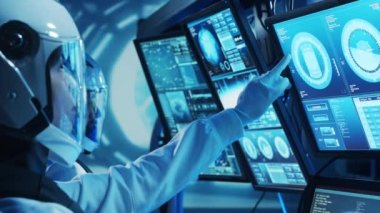 Yörünge istasyonunda uzay giysileri içinde bir astronot ekibi. Uzay gemisine pilotluk eden bir kozmonot mürettebatı. Uzayda kadın ve erkek. Galaktik seyahat ve bilim konsepti.