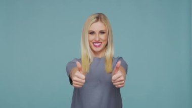 Stüdyodaki güzel sarışın kız. Mavi arka planda sevimli ve duygusal bir kızın portresi.