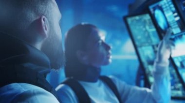 Yörünge istasyonunda uzay giysileri içinde bir astronot ekibi. Uzay gemisine pilotluk eden bir kozmonot mürettebatı. Uzayda kadın ve erkek. Galaktik seyahat ve bilim konsepti.