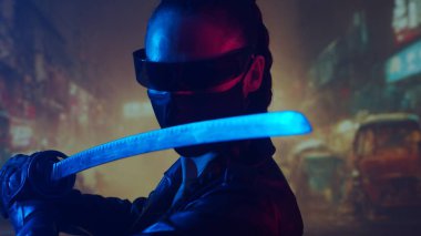 Maskeli ve katanalı siber-punk ninja kız. Şehir merkezindeki Asya şehrinin arka planında güzel bir kadın samuray..