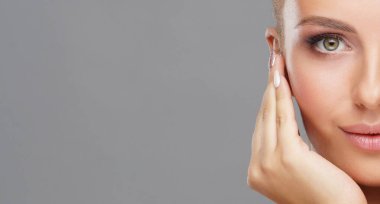 Genç ve sağlıklı kız gri arka plan üzerinde güzel yüzü. Cilt Bakımı, kozmetik ve yüz kavramı kaldırma.