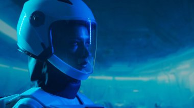 Yörünge istasyonunda uzay giysisi giymiş bir kadın astronot. Genç bir dişi kozmonot bir uzay gemisine pilotluk yapıyor. Galaktik seyahat ve bilim konsepti.