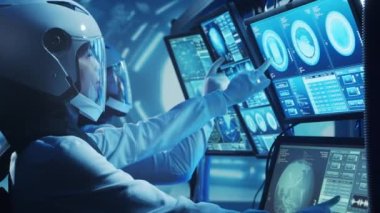 Yörünge istasyonunda uzay giysileri içinde bir astronot ekibi. Uzay gemisine pilotluk eden bir kozmonot mürettebatı. Uzayda kadın ve erkek. Galaktik seyahat ve bilim konsepti.