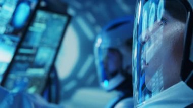 Yörünge istasyonunda uzay giysileri içinde bir astronot ekibi. Uzay gemisine pilotluk eden bir kozmonot mürettebatı. Uzayda kadın ve erkek. Galaktik seyahat ve bilim konsepti.