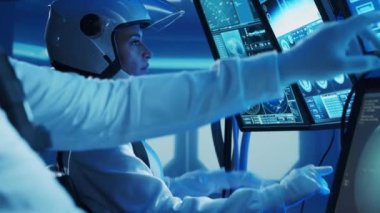 Yörünge istasyonunda uzay giysileri içinde bir astronot ekibi. Uzay gemisine pilotluk eden bir kozmonot mürettebatı. Uzayda kadın ve erkek. Galaktik seyahat ve bilim konsepti.