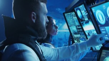 Yörünge istasyonunda uzay giysileri içinde bir astronot ekibi. Uzay gemisine pilotluk eden bir kozmonot mürettebatı. Uzayda kadın ve erkek. Galaktik seyahat ve bilim konsepti.