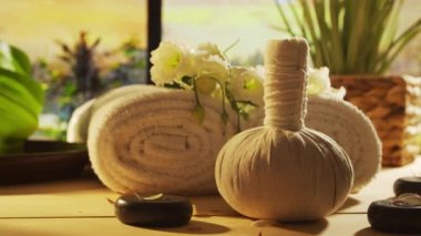 Spa background. Candles, flowers, massaging stones and herbal balls. The concept of massage, oriental therapy, wellbeing and meditation.