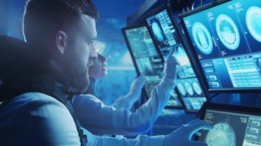 Yörünge istasyonunda uzay giysileri içinde bir astronot ekibi. Uzay gemisine pilotluk eden bir kozmonot mürettebatı. Uzayda kadın ve erkek. Galaktik seyahat ve bilim konsepti.