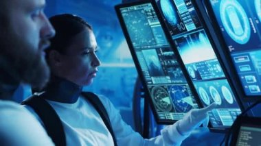 Yörünge istasyonunda uzay giysileri içinde bir astronot ekibi. Uzay gemisine pilotluk eden bir kozmonot mürettebatı. Uzayda kadın ve erkek. Galaktik seyahat ve bilim konsepti.