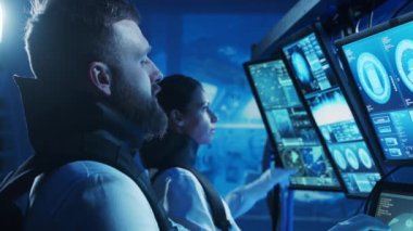 Yörünge istasyonunda uzay giysileri içinde bir astronot ekibi. Uzay gemisine pilotluk eden bir kozmonot mürettebatı. Uzayda kadın ve erkek. Galaktik seyahat ve bilim konsepti.