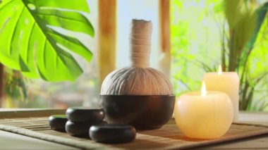 Spa background. Candles, flowers, massaging stones and herbal balls. The concept of massage, oriental therapy, wellbeing and meditation.