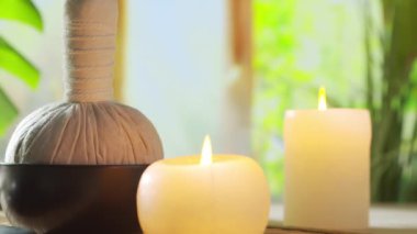 Spa background. Candles, flowers, massaging stones and herbal balls. The concept of massage, oriental therapy, wellbeing and meditation.