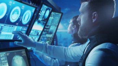 Yörünge istasyonunda uzay giysileri içinde bir astronot ekibi. Uzay gemisine pilotluk eden bir kozmonot mürettebatı. Uzayda kadın ve erkek. Galaktik seyahat ve bilim konsepti.